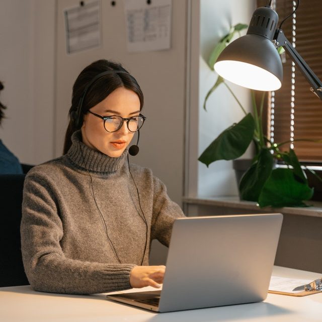 Kobieta w słuchawkach na lekcji angielskiego online – angielski dla firm